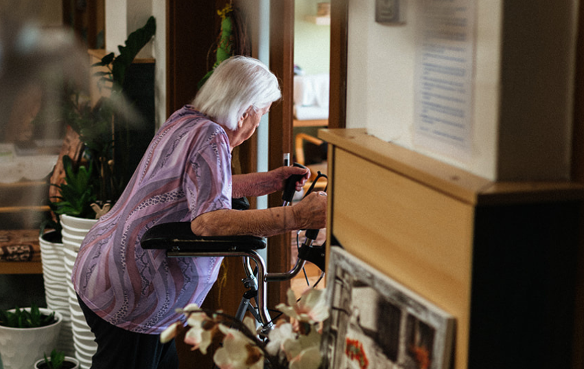 Seniorka s chodítkem v domově pro seniory
